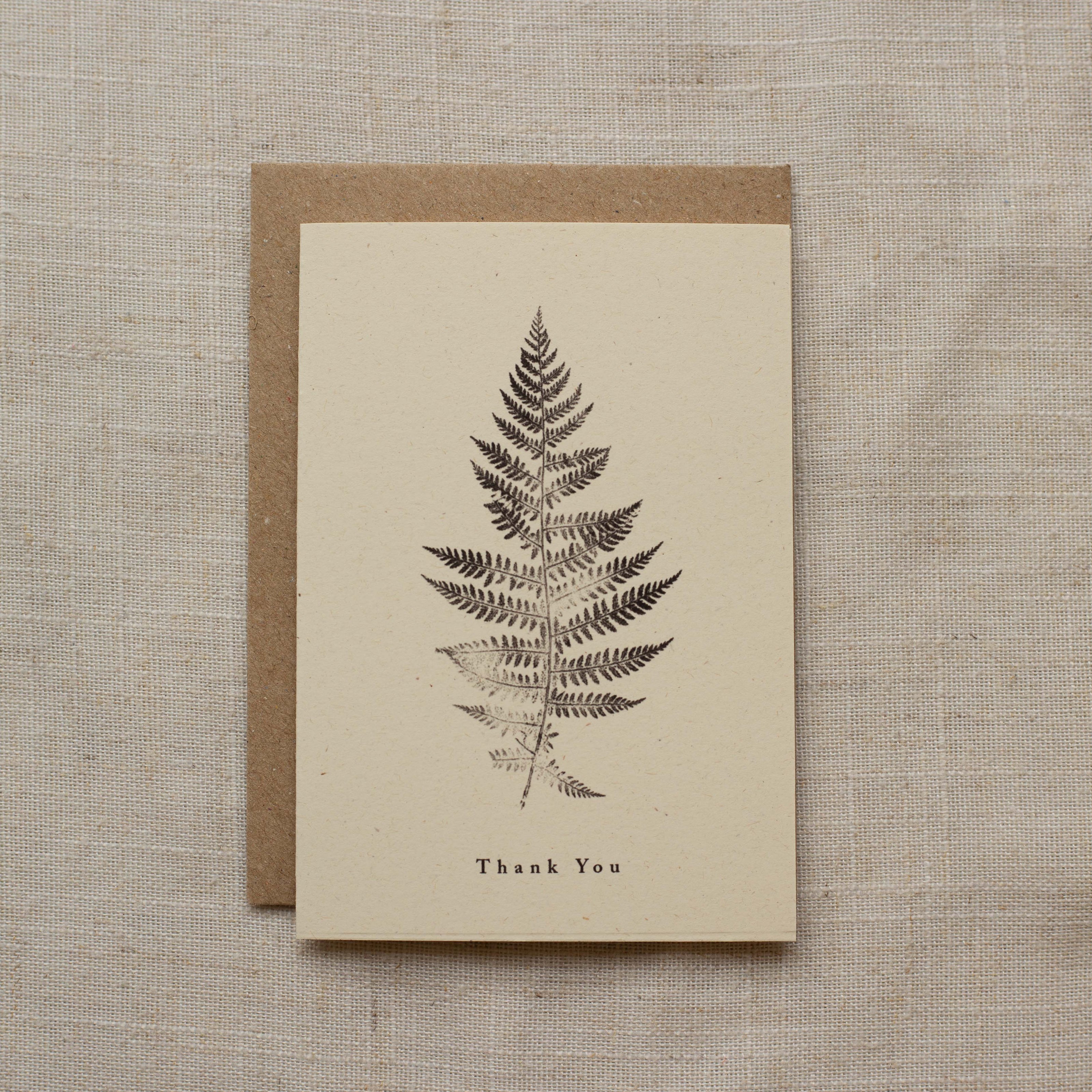 Greeting card with fern design and 'Thank You' text on a matte beige background