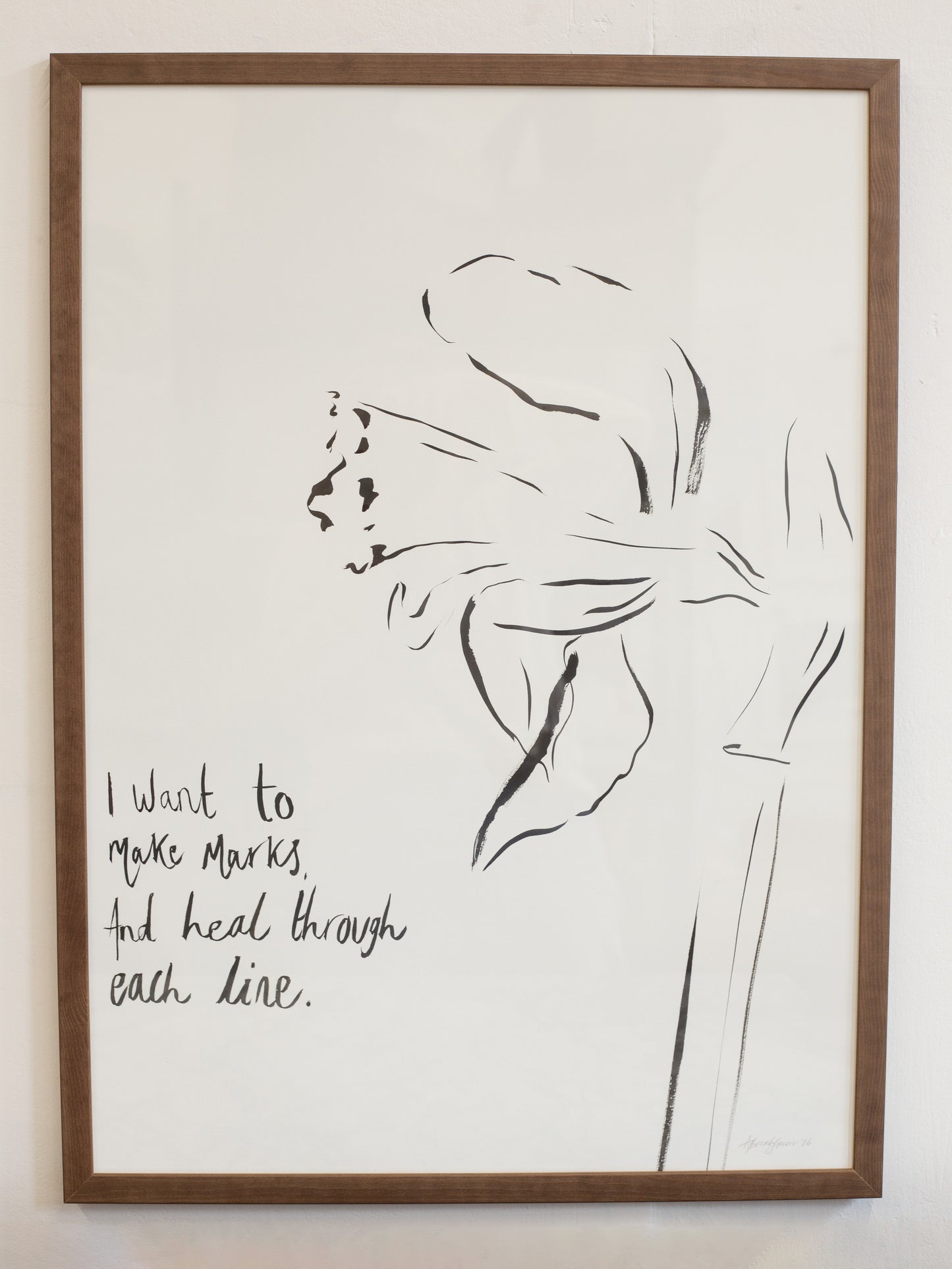 Framed artwork with a black line drawing of a flower and text on a white background