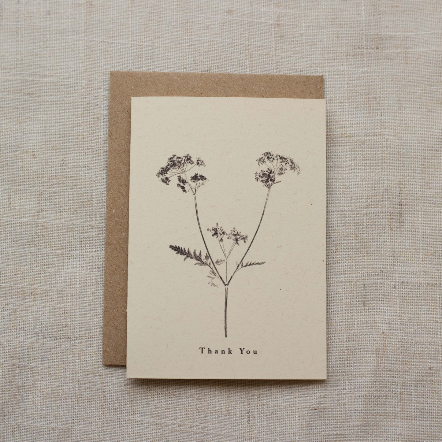 Greeting card with floral design and 'Thank You' text on a matte beige background
