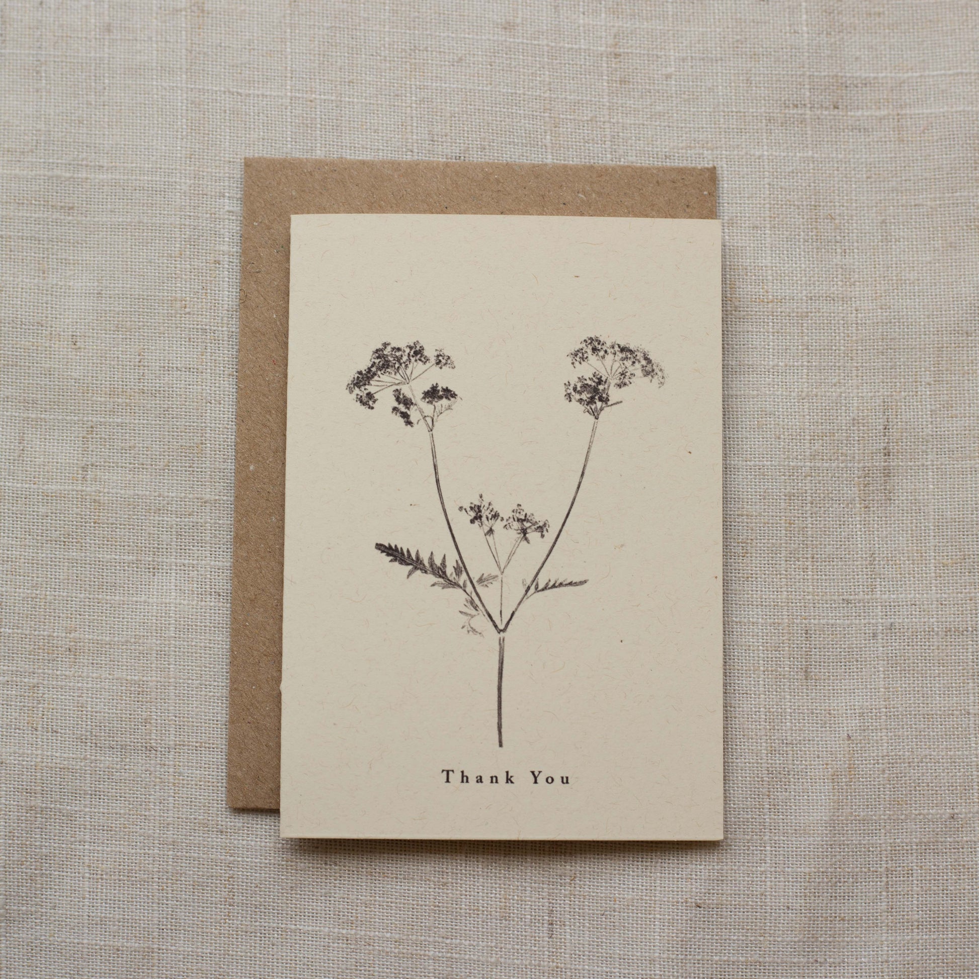 Greeting card with floral design and 'Thank You' text on a matte beige background
