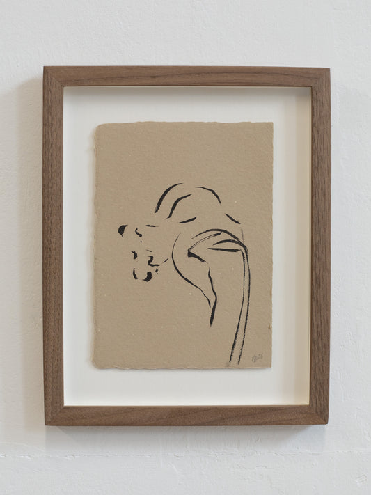 Framed minimalist floral line art of a daffodil on beige paper against a white wall.