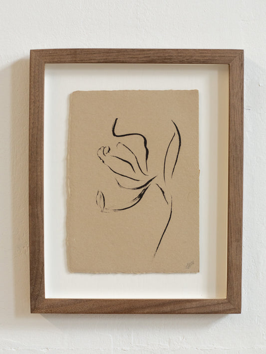 Framed floral abstract black line drawing on beige paper against a white wall
