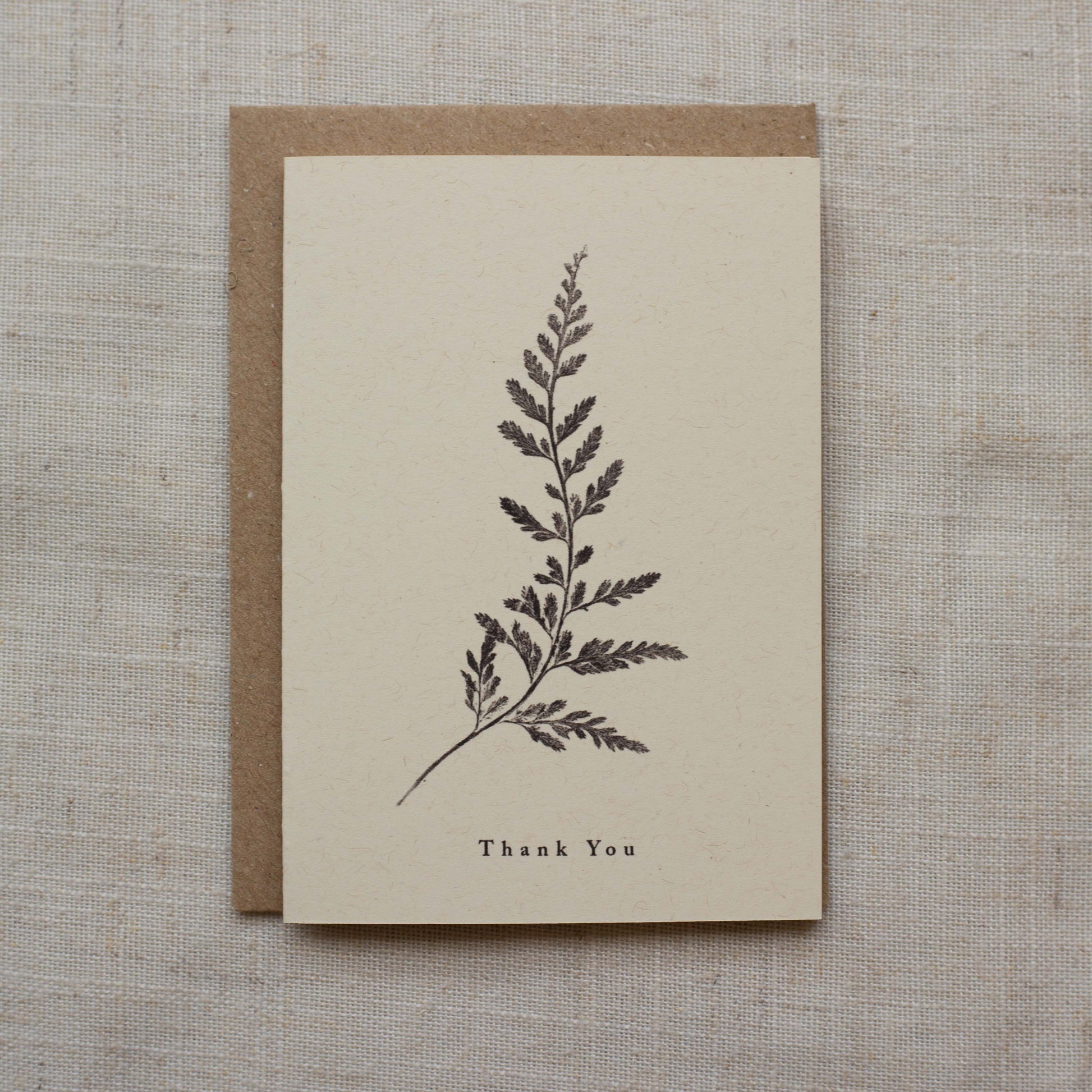 Greeting card with fern design and 'Thank You' text on a matte beige background