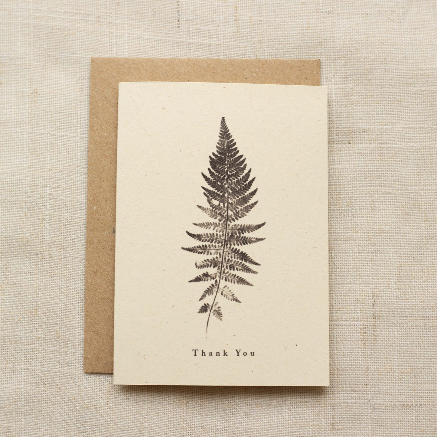 Greeting card with fern design and 'Thank You' text on a matte beige background