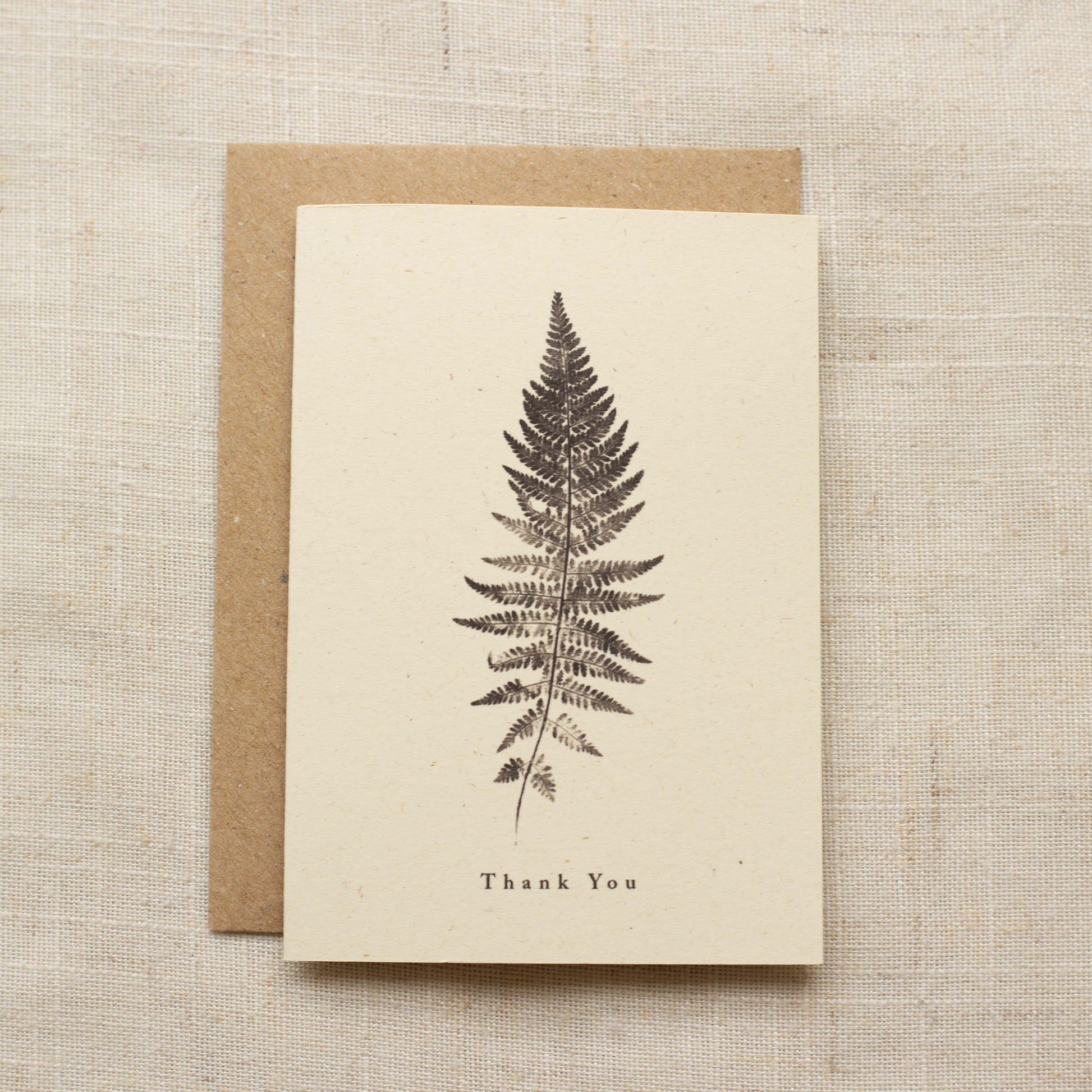 Greeting card with fern design and 'Thank You' text on a matte beige background