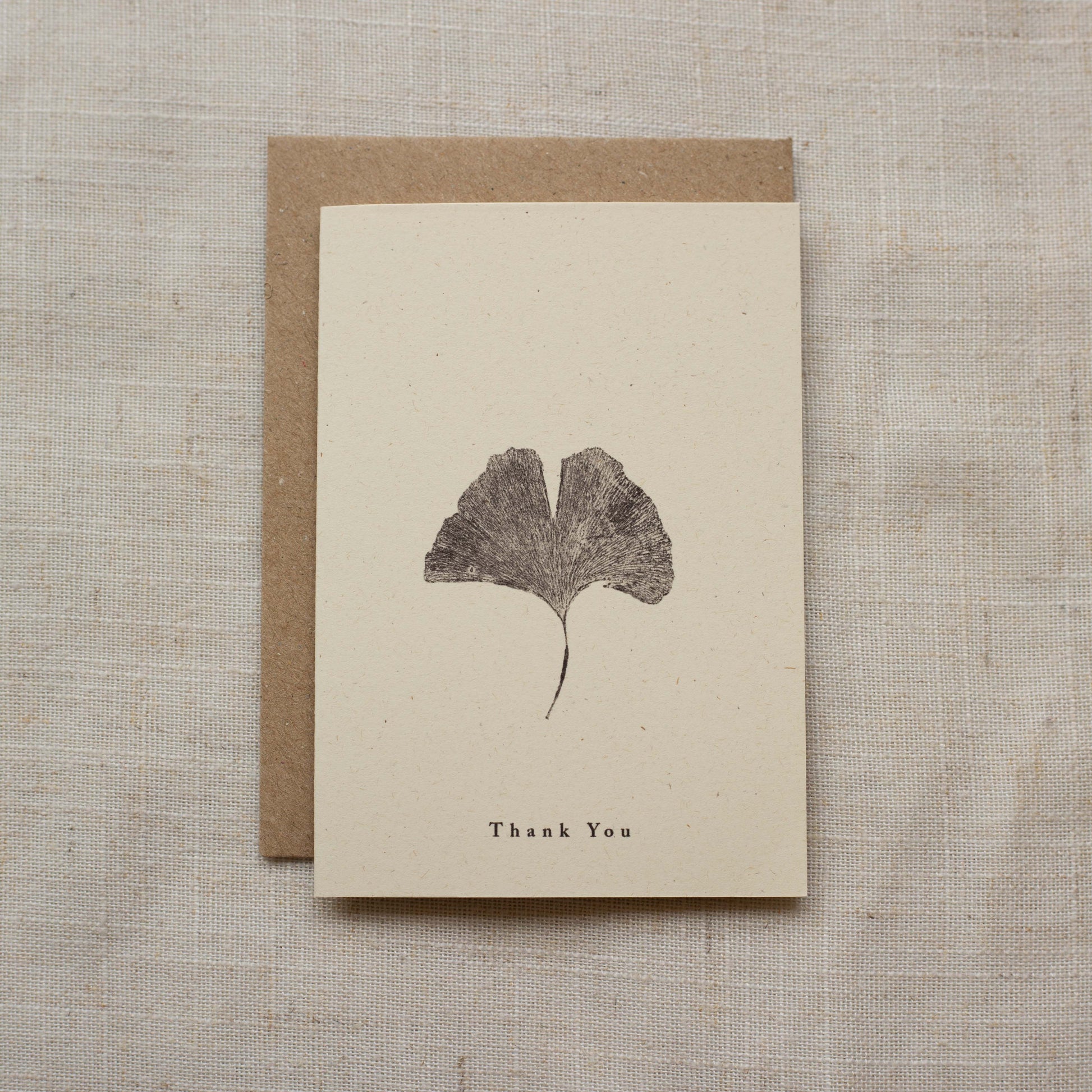 Greeting card with leaf design and 'Thank You' text on a textured surface