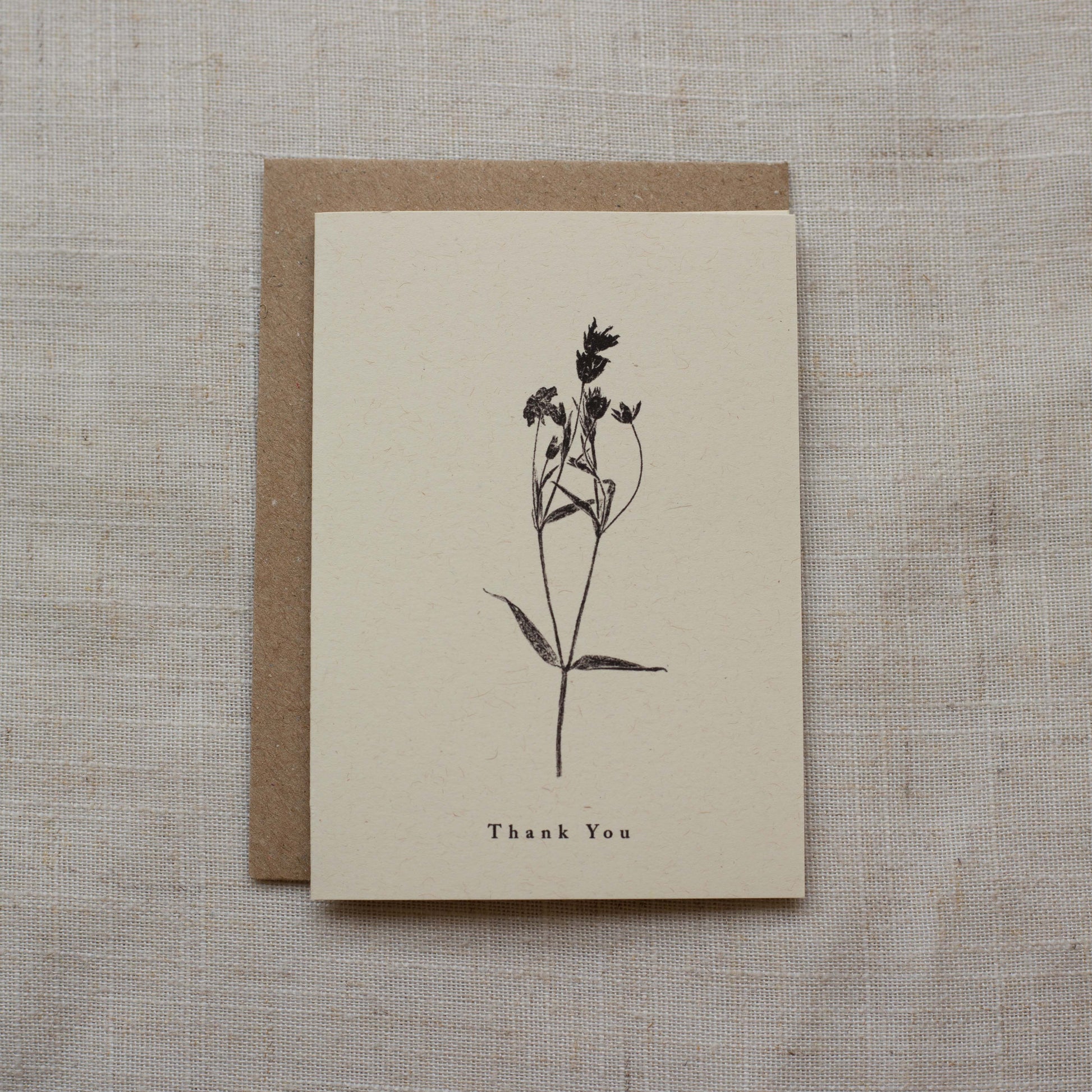 Greeting card with plant illustration and 'Thank You' text on a textured surface
