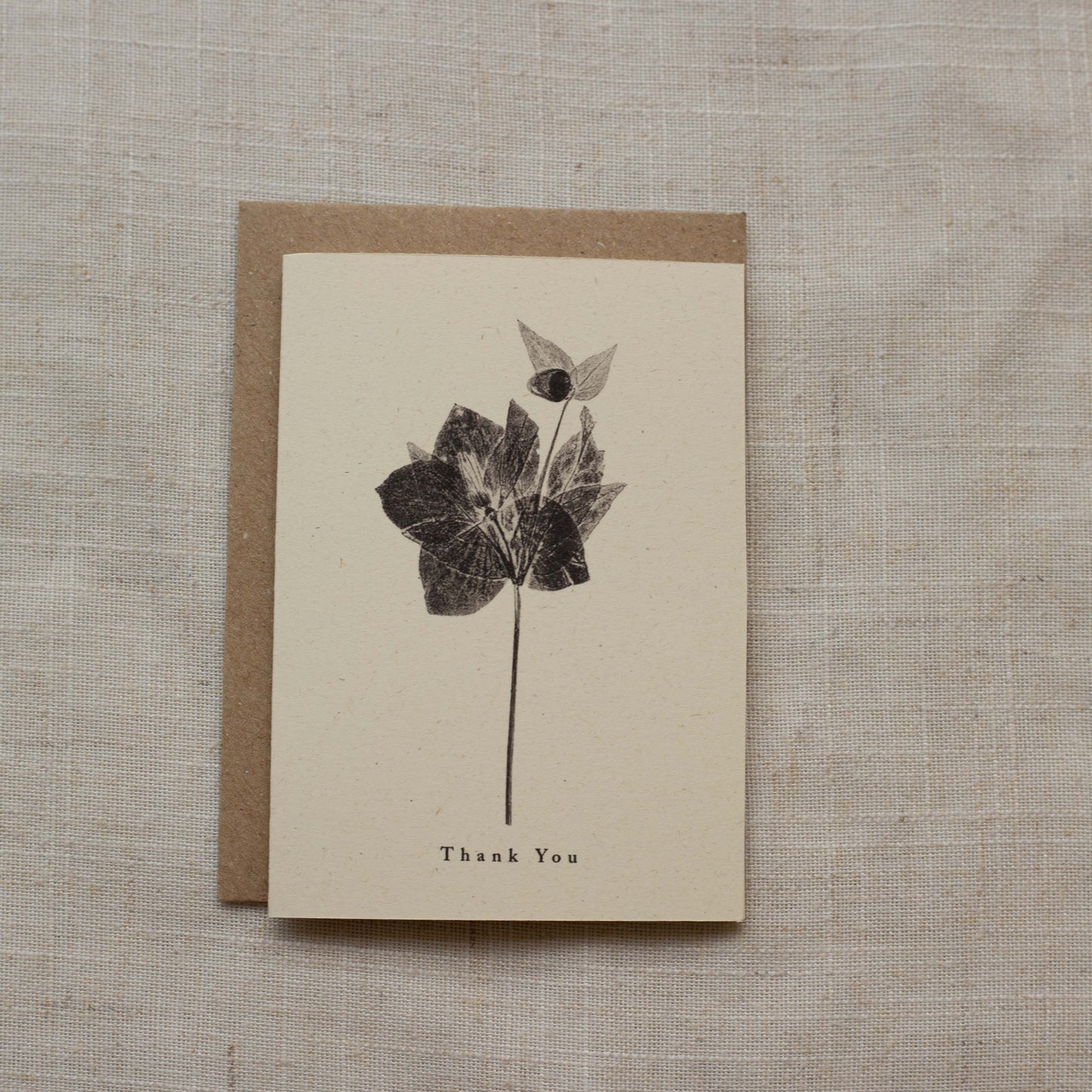 Greeting card with flower design and 'Thank You' text on a textured surface