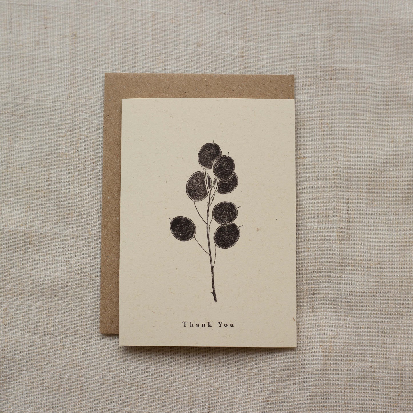 Greeting card with floral design and 'Thank You' text on a matte beige background