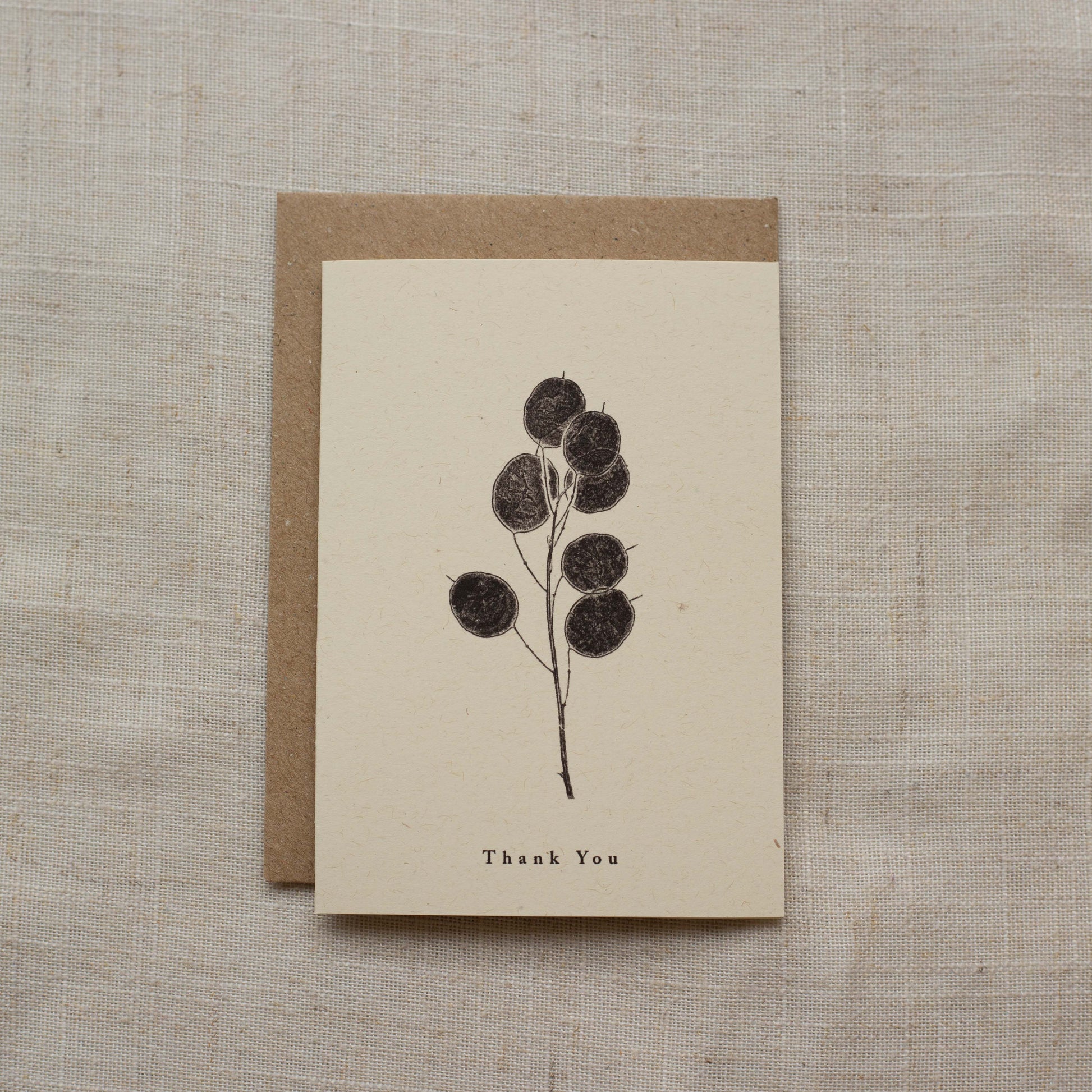 Greeting card with floral design and 'Thank You' text on a matte beige background