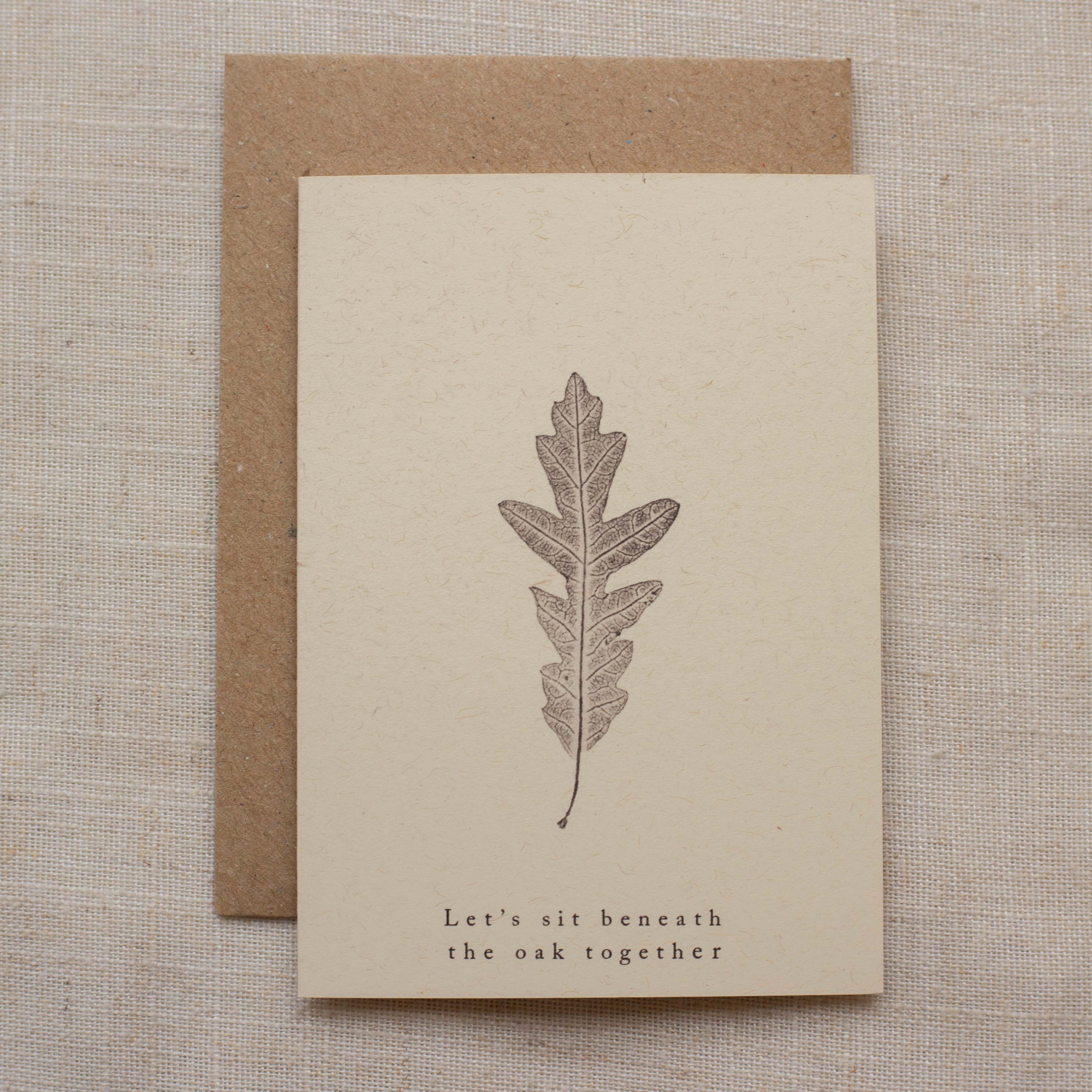 Card with leaf design and text on beige paper with brown envelope