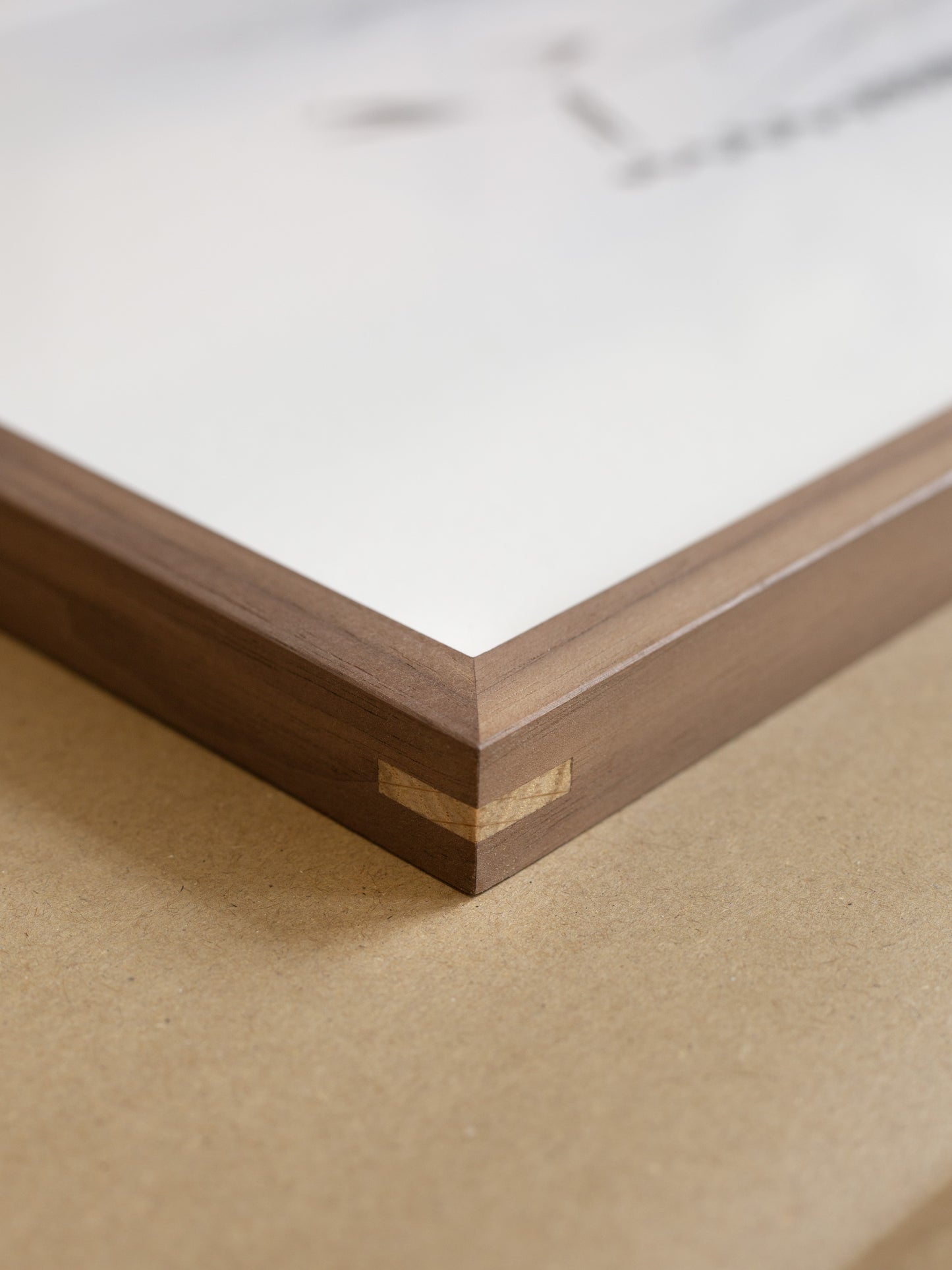 Close-up of a wooden frame corner on a beige surface