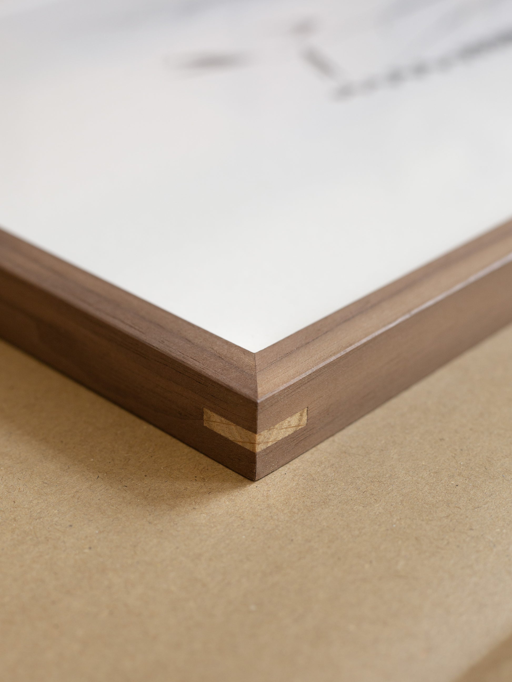 Close-up of a wooden frame corner on a beige surface