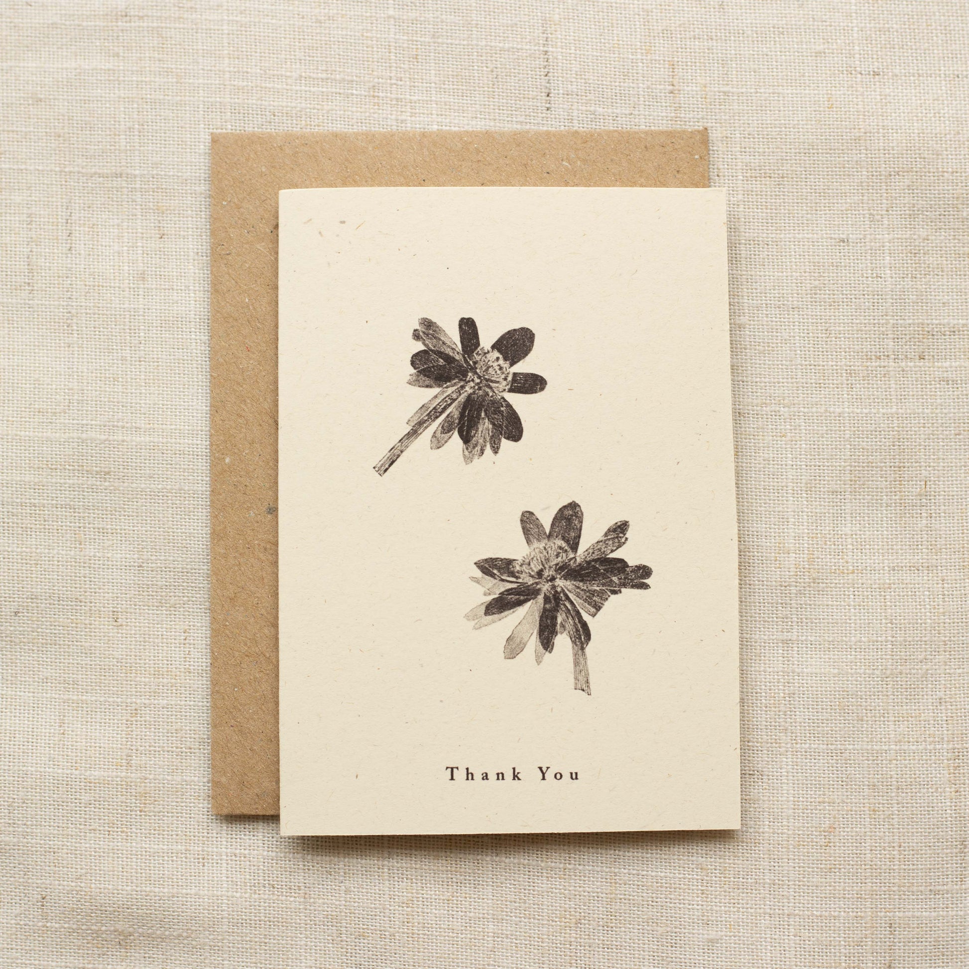 Greeting card with floral illustrations and 'Thank You' text on a matte beige background