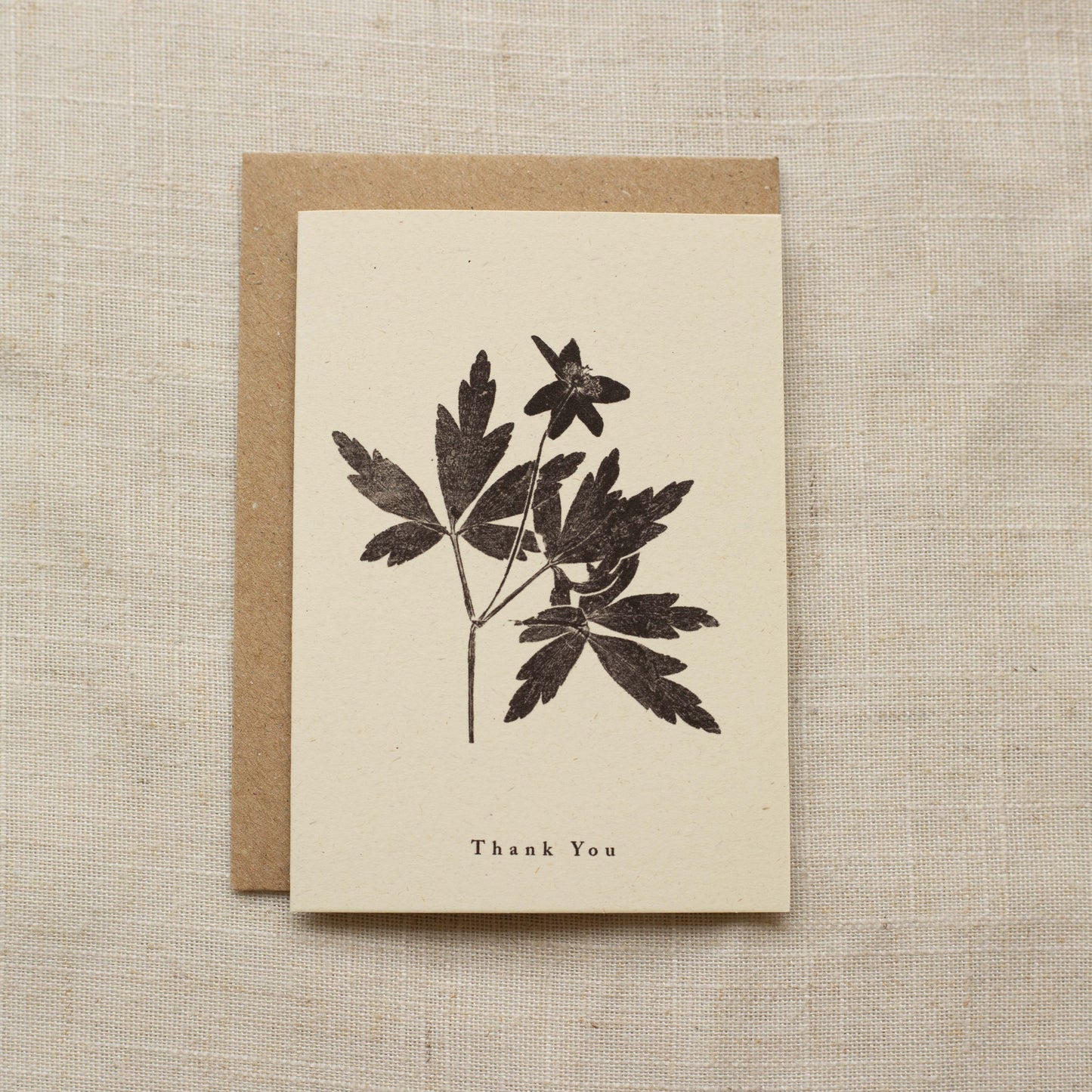 Greeting card with floral design and 'Thank You' text on a matte beige background