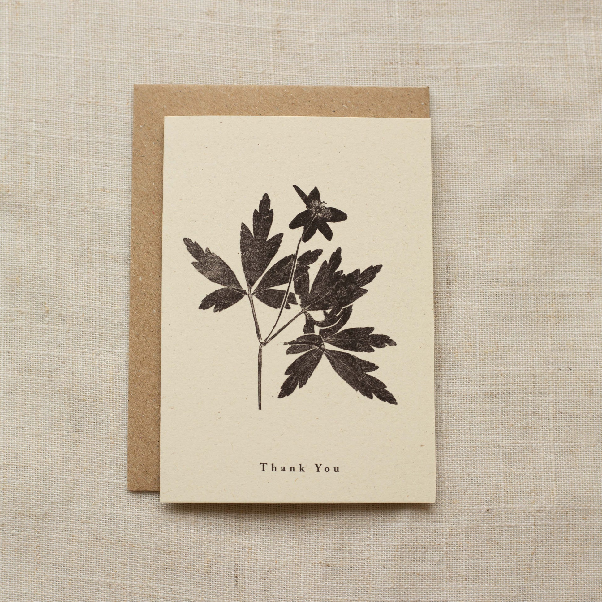 Greeting card with floral design and 'Thank You' text on a matte beige background